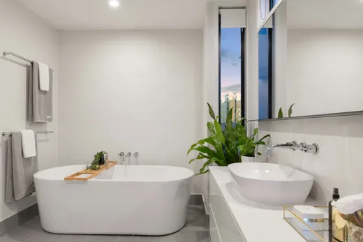 Freestanding tub with a marble tub deck and tiled wall