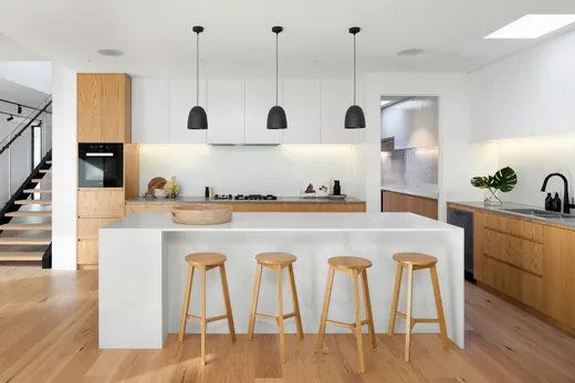 Kitchen island with a quartz waterfall countertop and tile floor